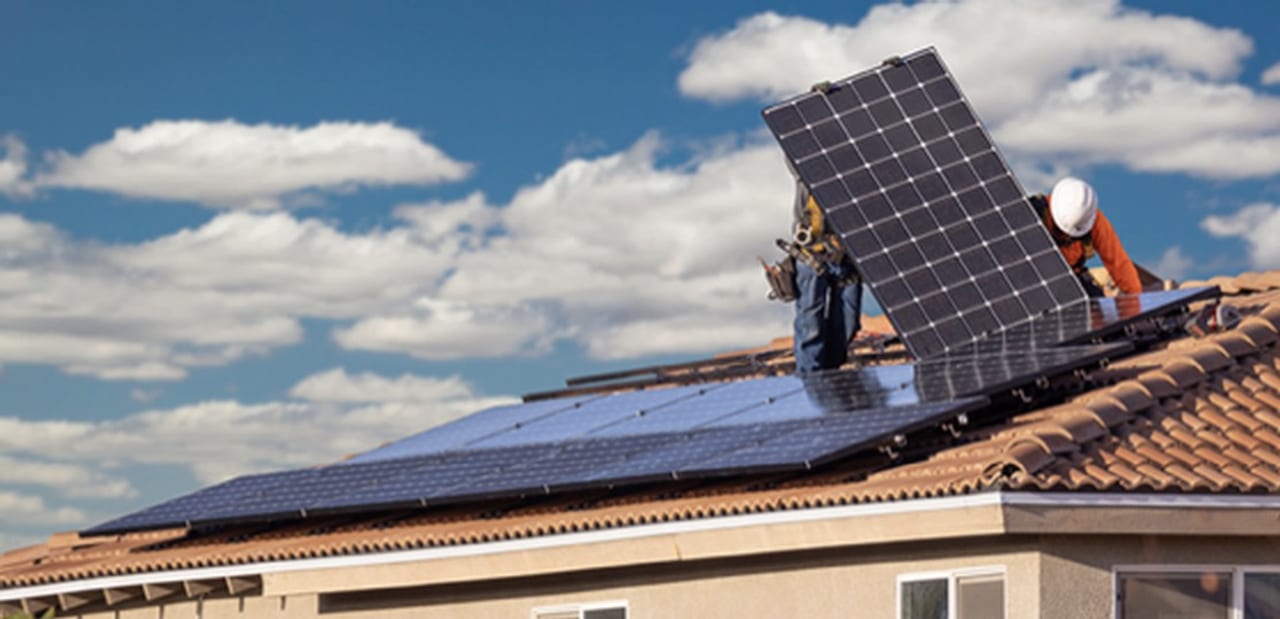 Instaladores colocando paneles solares en techo de tejas